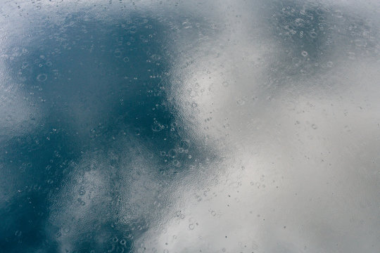 rain drops on water with reflection of sky