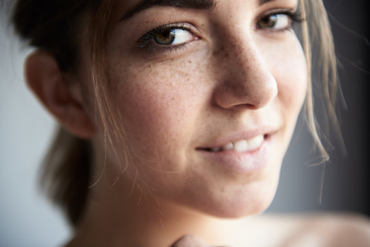 Young freckled woman looking at camera