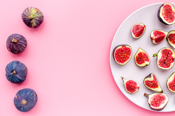 Fresh blue figs on the plate on pink background top view copyspace