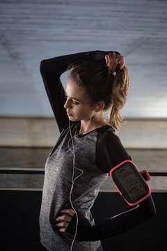 Woman listening to music in fitness studio