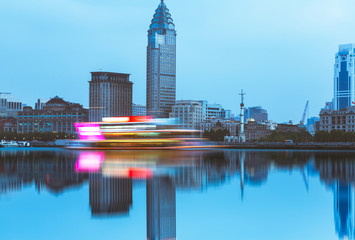 the bund skyline with blurred cruise boat on huangpu river,shanghai,china.