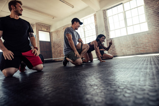 Young People Chatting In The Gym During Warmup Exercise