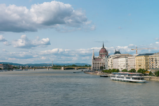 The Hungarian Parliament Building on the bank of the Danube in Budapest. Sunny day with clouds