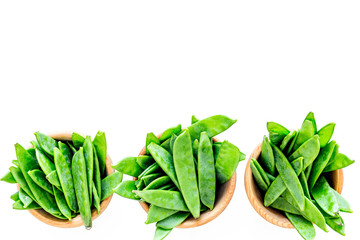 Fresh green pea pods in bowls on white background top view copyspace