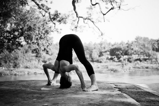Woman doing yoga at the riverside