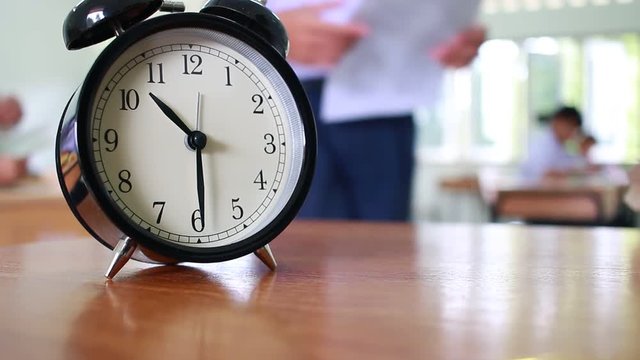 Alam clock located on wood teacher table in final exam room of secondary school, college university classroom students in Asia, Thailand. It show a timeout sign. in secondary school, Education concept