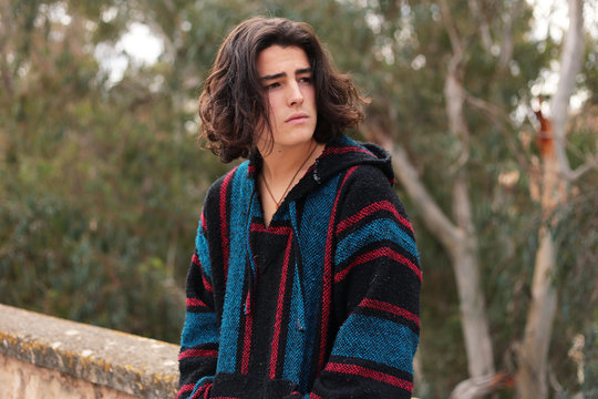 Bohemian teenage boy with long hair outdoors