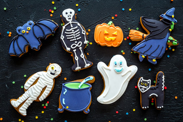 Bright halloween gingerbread cookies background on black background top view