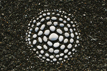 white stones arranged in circular pattern on beach