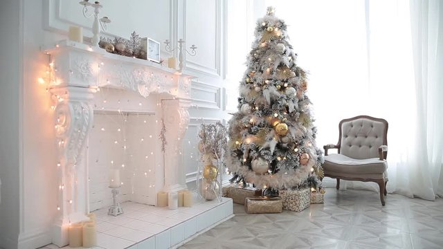 White classic Christmas and New Year interior room with fireplace, green tree decorated and retro grey chair