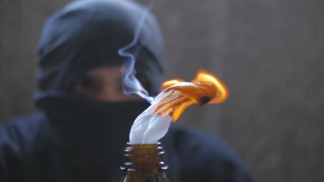 Black bloc anarchist behind the molotov cocktail