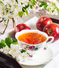 Cup of tea on wooden table and apple blossom