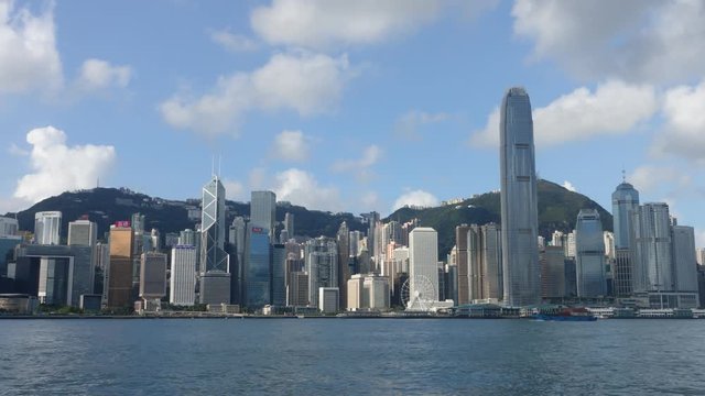 Hong Kong skyline at sunrise in morning.  View of Kowloon pier, avenue of stars in Tsim Sha Tsui.  Victoria Harbour, Central, Causeway Bay cityscape. Passenger cargo ship traffic transport. Time lapse