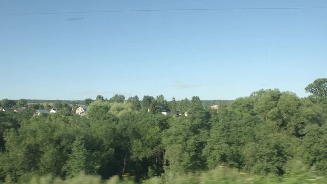 POV: High-speed Train moves past a fields and low trees