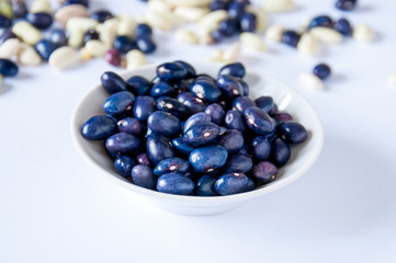In a white plate, blue bean stands on table