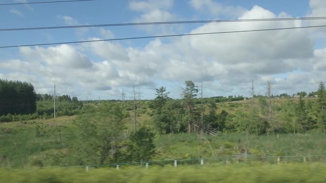 POV: High-speed Train fast moves past a power station and a fields in the summer