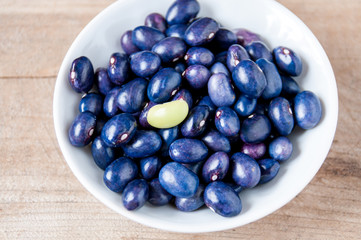 One green bean among the blue in a white plate