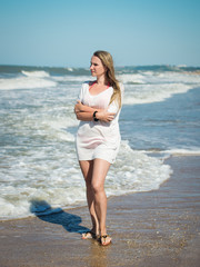 Beautiful woman in white clothes in bright sunlight on the ocean.