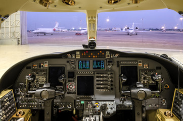 Corporate jet cockpit with digital instruments parking in the garage