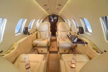 Luxury interior of genuine leather in the modern business jet and sunlight at the window