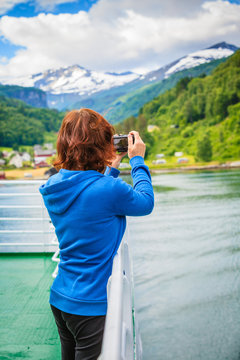 Tourist woman on liner taking photo, Norway