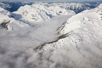 Fototapeta na wymiar Beautiful aerial landscape view of the snow covered mountain range with a low level cloud. Taken in the remote area early morning North West from Vancouver, British Columbia, Canada.