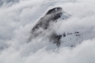 Aerial Landscape View of the mountain peak covered in clouds. Taken in remote part of British Columbia, Canada.