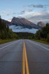 Road with mountains in the background. Taken in Icefields Pkwy, Banff National Park, Alberta, Canada.