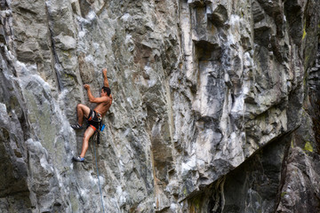 Fototapeta premium Rock climber climbing a steep rock face in Squamish, British Columbia, Canada.