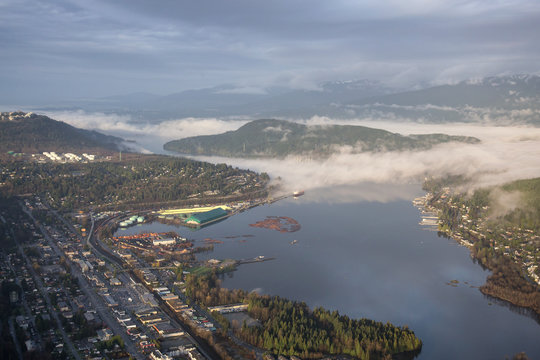 Aerial View of Port Moody, Greater Vancouver, British Columbia, Canada. Taken during a cloudy sunrise with fog patches.