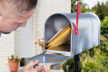 Man opening his mailbox to remove mail