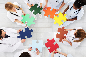 Group Of Doctors Holding Colorful Puzzle