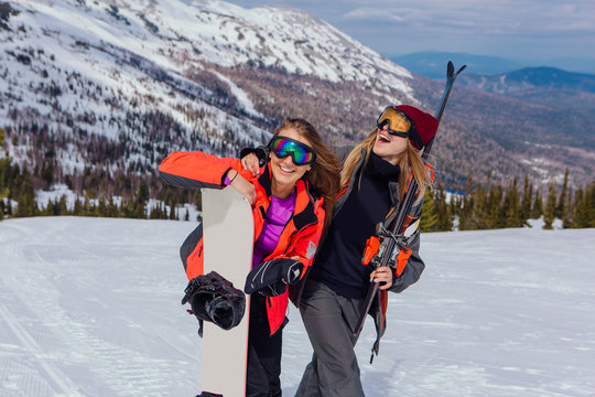 Two young women with ski and snowboard
