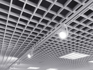 row of bright halogen spotlights on exhibition ceiling grid