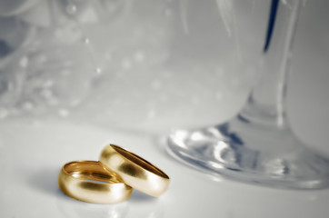 Gold wedding rings and focal on a light background.