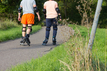 young couple on outdoor exercise with inline skaters