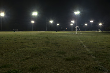 Fototapeta na wymiar Empty athletic soccer fields at night with lights on