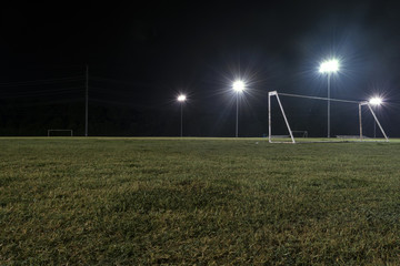 Low angle night photo of goal on empty soccer field © Stretch Clendennen