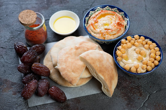 Fresh pita bread with hummus and date fruits, selective focus, studio shot