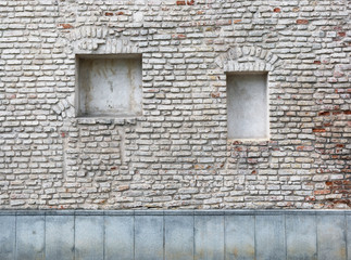 Fototapeta na wymiar Blind curved basement windows in the old aged red bricks house