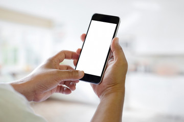 Man hands holding blank screen smartphone with blurred background. Blank screen for graphic display montage.