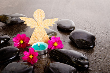 Obraz na płótnie Canvas Pink Cosmos Flowers, blue tealight candle and burlap angel shape on black massage rocks