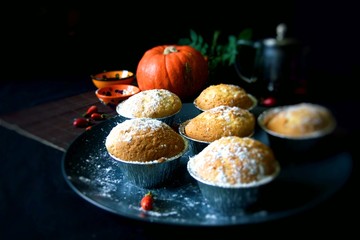 Homemade Lemon muffins in baking dish close up on black background.