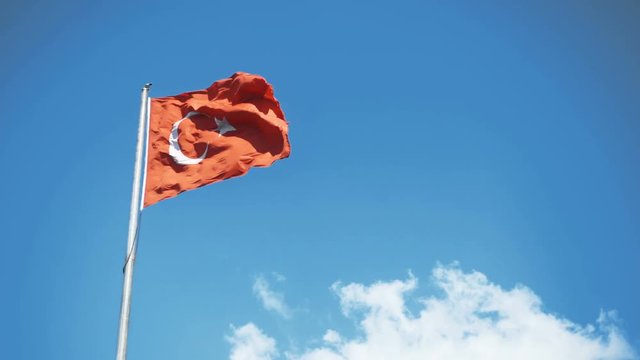 Turkish flag waving in blue sky outdoors