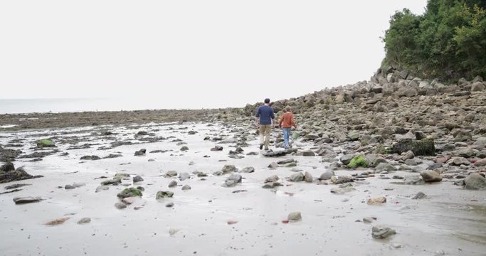 Father and Son exploring a rock pools on beach