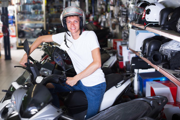 Male in helmet is sitting on motorbike