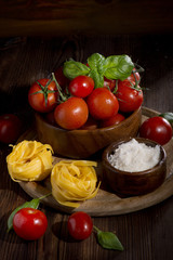 pasta tomatoes basil pomezan cheese wooden cups black background