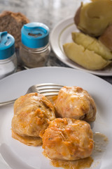 Flat lay above served meal with sarma cooked potatoes salt pepper and bread