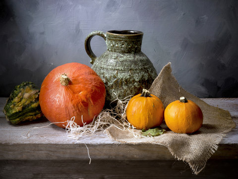 still-life classic pumpkin decorative scenic background wooden shelf burlap green jug