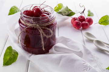 Delicious apple jam with whole apples on a white background.